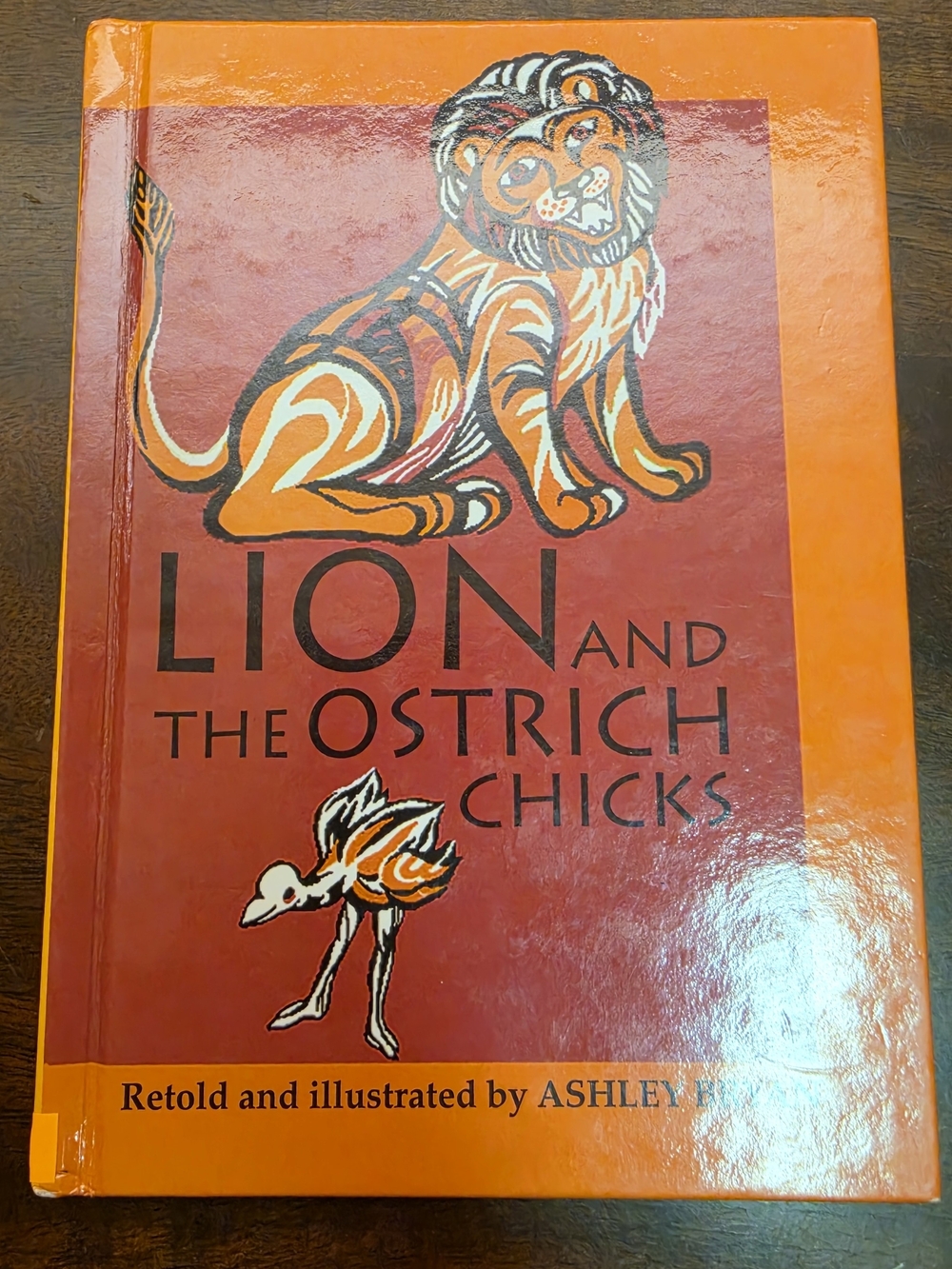 Lion and the Ostrich Chicks Hardcover Book - Orange & Red Cover